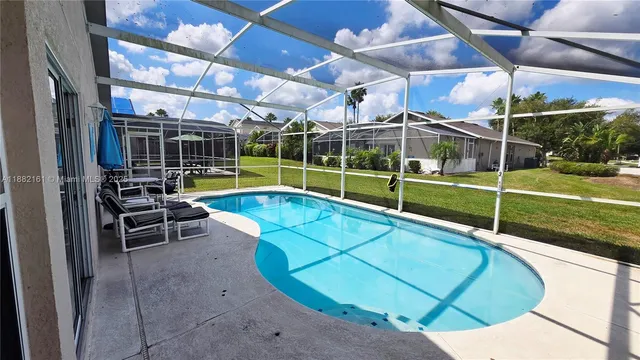 a view of a swimming pool with a patio and a yard