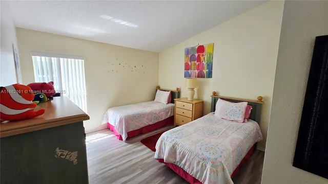 a bedroom with two beds and a potted plant