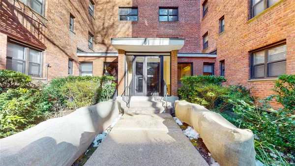 a view of a brick building with a large windows and flower plants