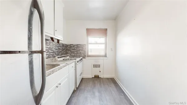 a kitchen with white cabinets and white appliances