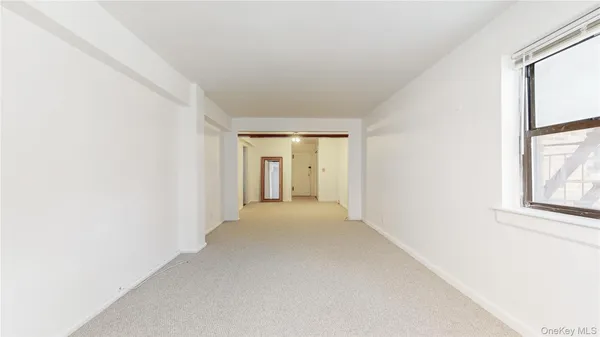 a view of a big room with windows and chandelier fan
