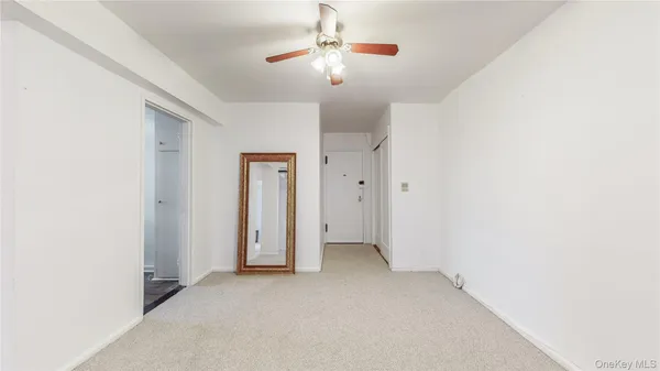 an empty room with a ceiling fan and a window