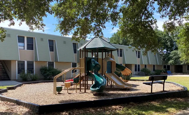 a view of a house with backyard water fountain and sitting area