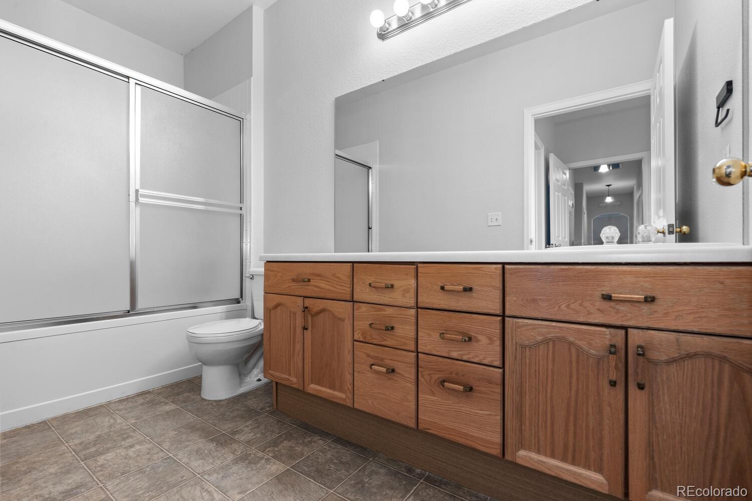 14251 East 1st Drive, Unit 305 Aurora, CO 80011 - Photo 11 of 22 a bathroom with a toilet a sink and mirror