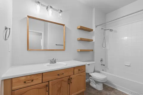 a bathroom with a toilet a sink a mirror a shower and vanity