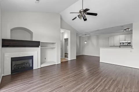 a view of empty room with wooden floor and fireplace