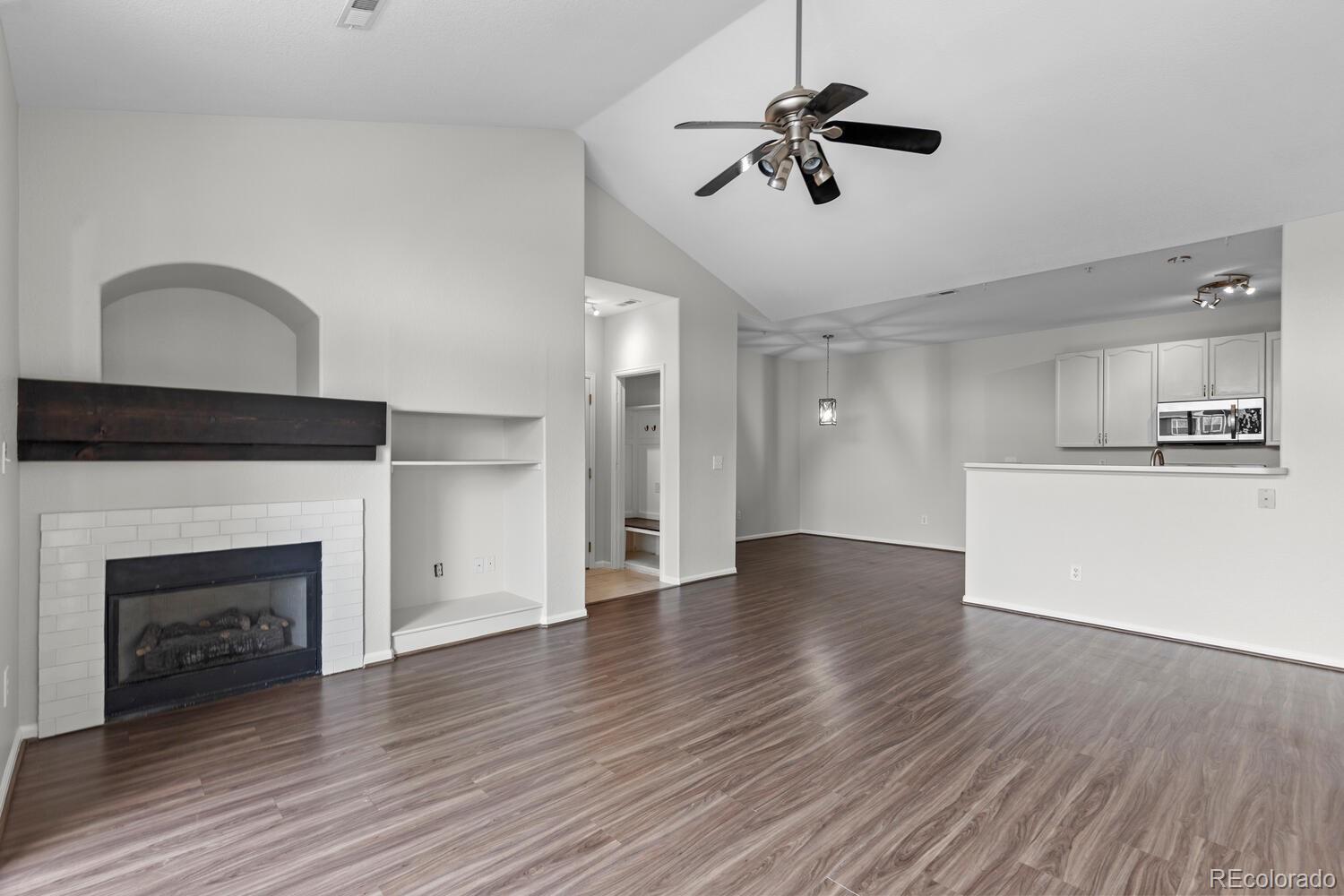 14251 East 1st Drive, Unit 305 Aurora, CO 80011 - Photo 3 of 22 a view of empty room with wooden floor and fireplace