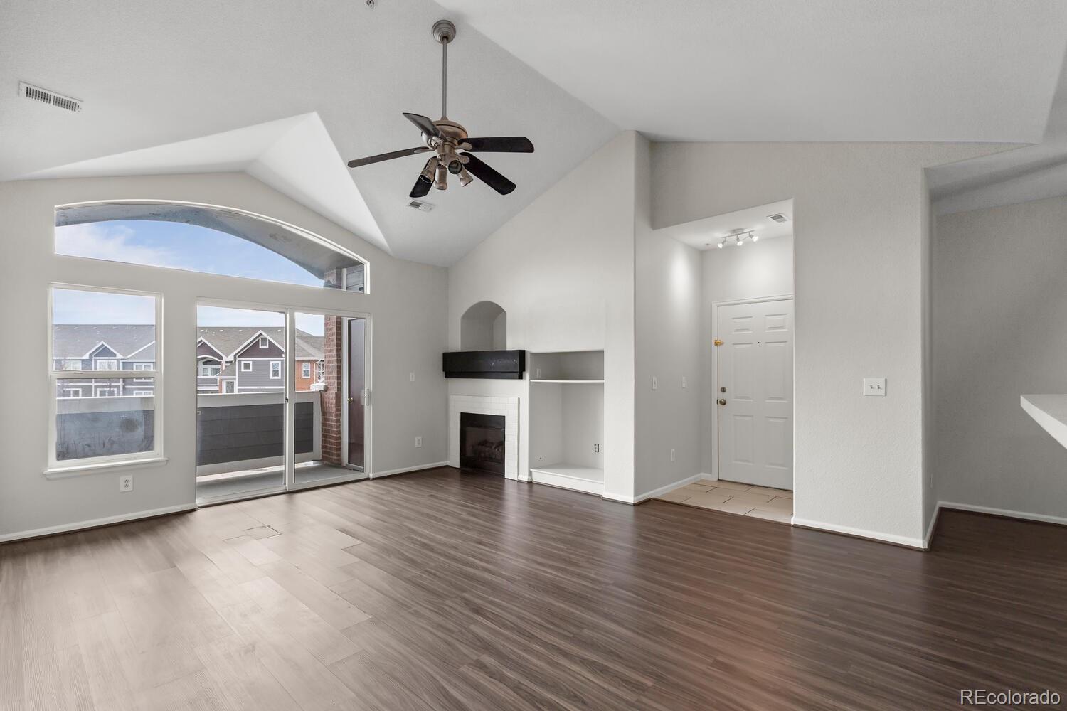 14251 East 1st Drive, Unit 305 Aurora, CO 80011 - Photo 4 of 22 a view of a big room with wooden floor a ceiling fan and windows