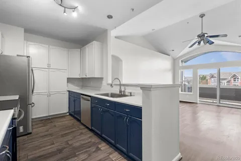 a kitchen with stainless steel appliances granite countertop a sink cabinets and wooden floor