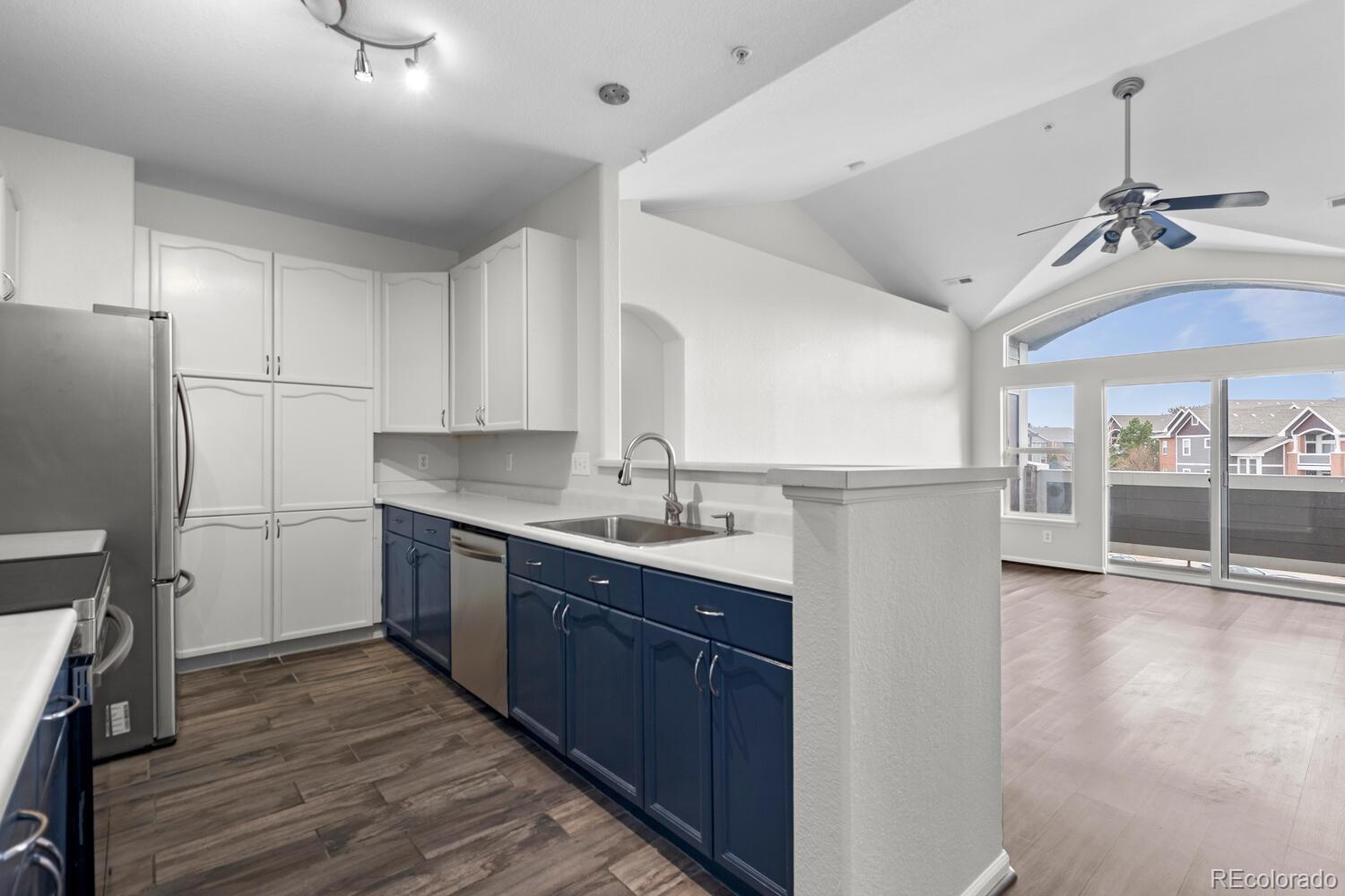 14251 East 1st Drive, Unit 305 Aurora, CO 80011 - Photo 5 of 22 a kitchen with stainless steel appliances granite countertop a sink cabinets and wooden floor