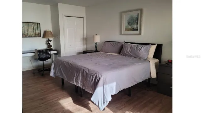 a bedroom with a bed and wooden floor