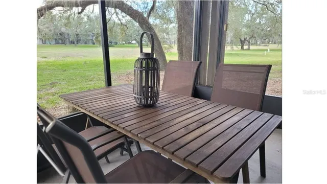 a view of a patio with a table chairs and a backyard