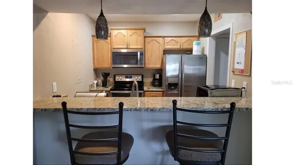 a kitchen with granite countertop a sink cabinets and stainless steel appliances