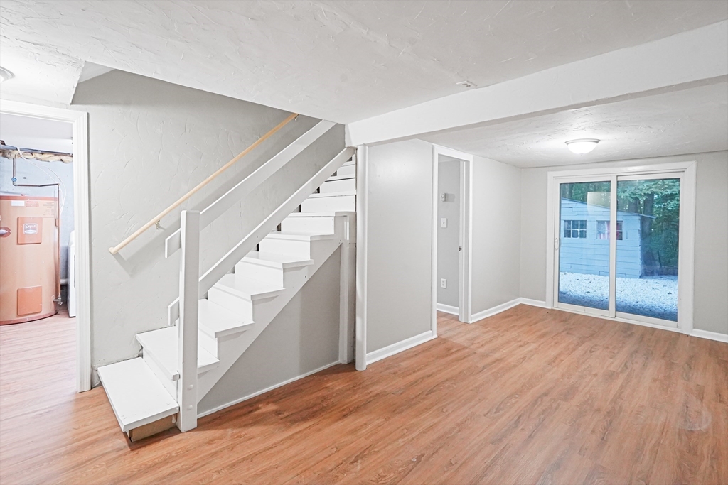 5-9 Debra Lane Bellingham, MA 02019 - Photo 11 of 25 a view of an empty room with wooden floor and stairs
