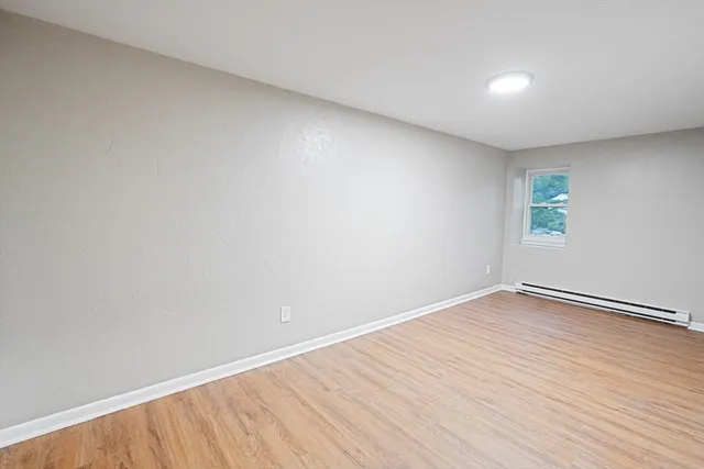 a view of empty room with wooden floor