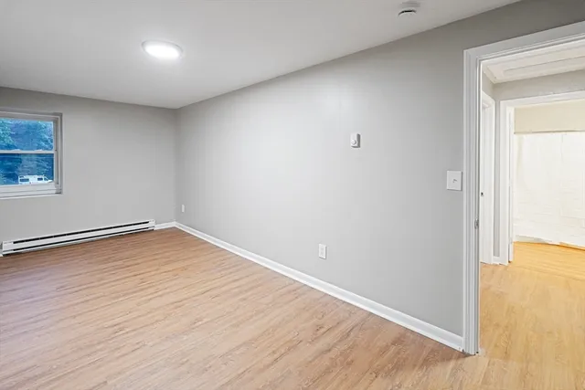a view of empty room with wooden floor