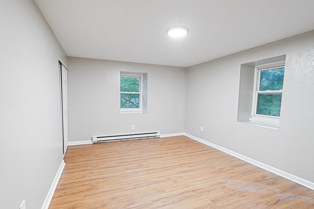 5-9 Debra Lane Bellingham, MA 02019 - Photo 21 of 25 an empty room with wooden floor and windows