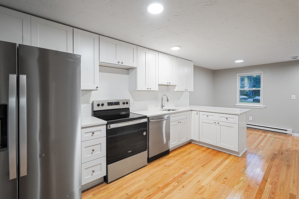 5-9 Debra Lane Bellingham, MA 02019 - Photo 5 of 25 a kitchen with white cabinets and stainless steel appliances