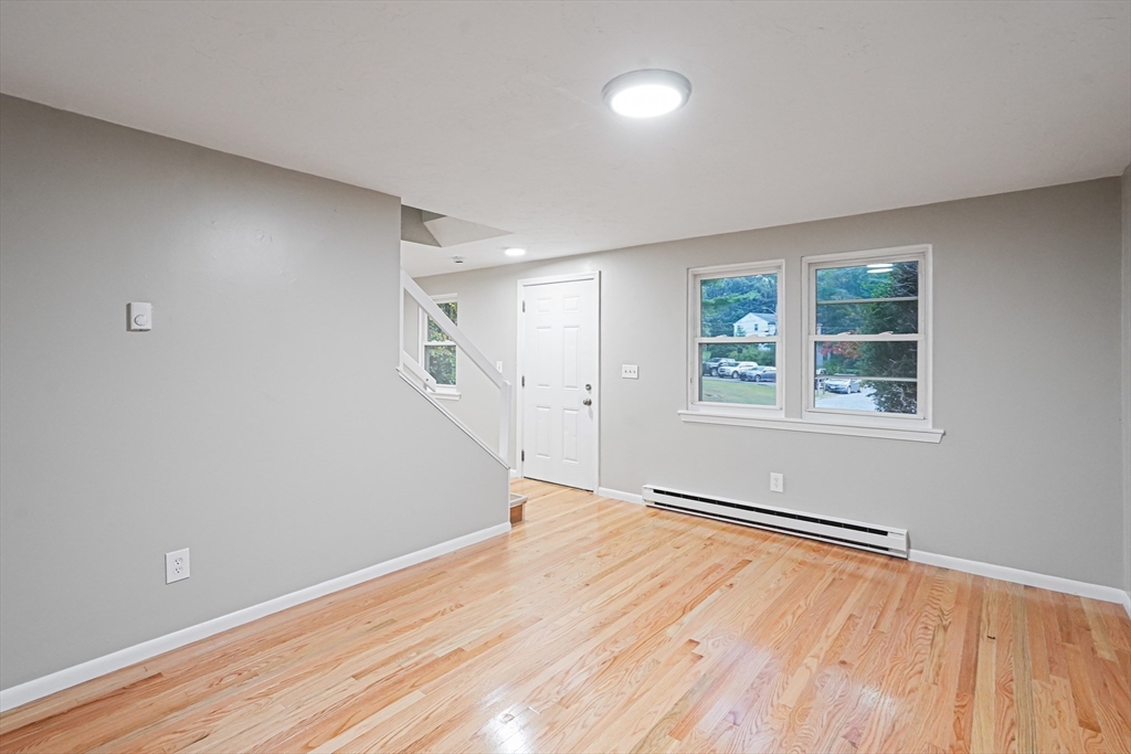 5-9 Debra Lane Bellingham, MA 02019 - Photo 7 of 25 a view of empty room with wooden floor and fan