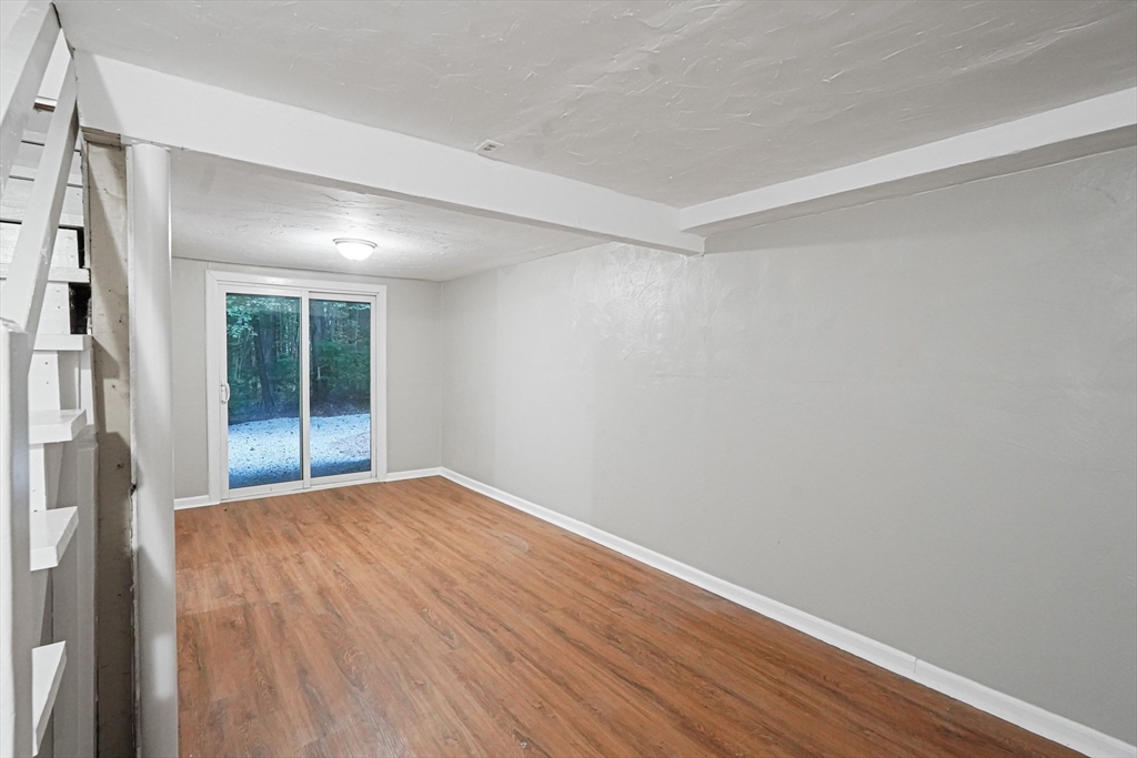 5-9 Debra Lane Bellingham, MA 02019 - Photo 10 of 25 a view of an empty room with wooden floor and a window