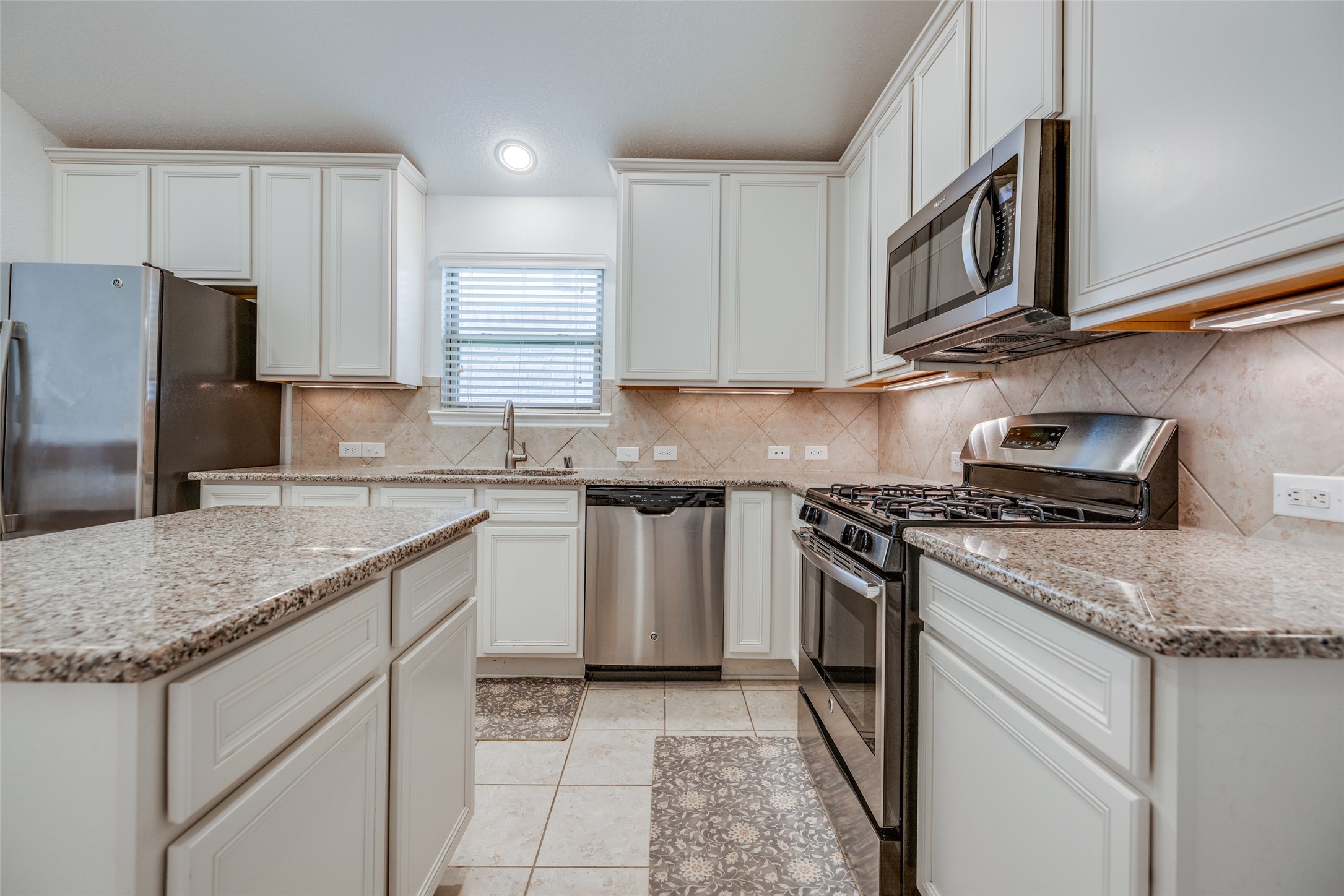 7123 Panther Ridge Drive Spring, TX 77389 - Photo 12 of 31 a kitchen with stainless steel appliances granite countertop a sink stove microwave and refrigerator