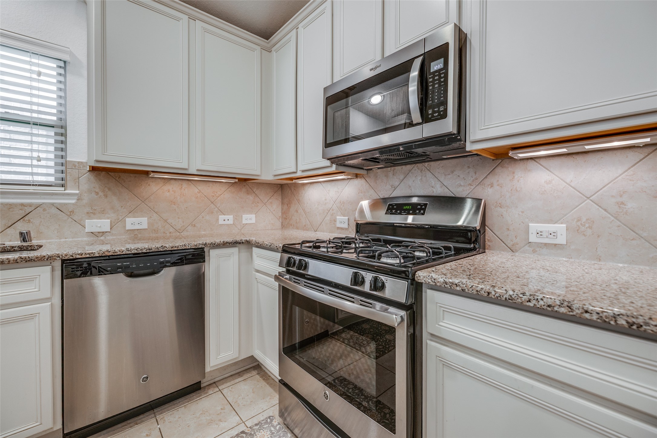 7123 Panther Ridge Drive Spring, TX 77389 - Photo 13 of 31 a kitchen with granite countertop white cabinets stainless steel appliances and a sink