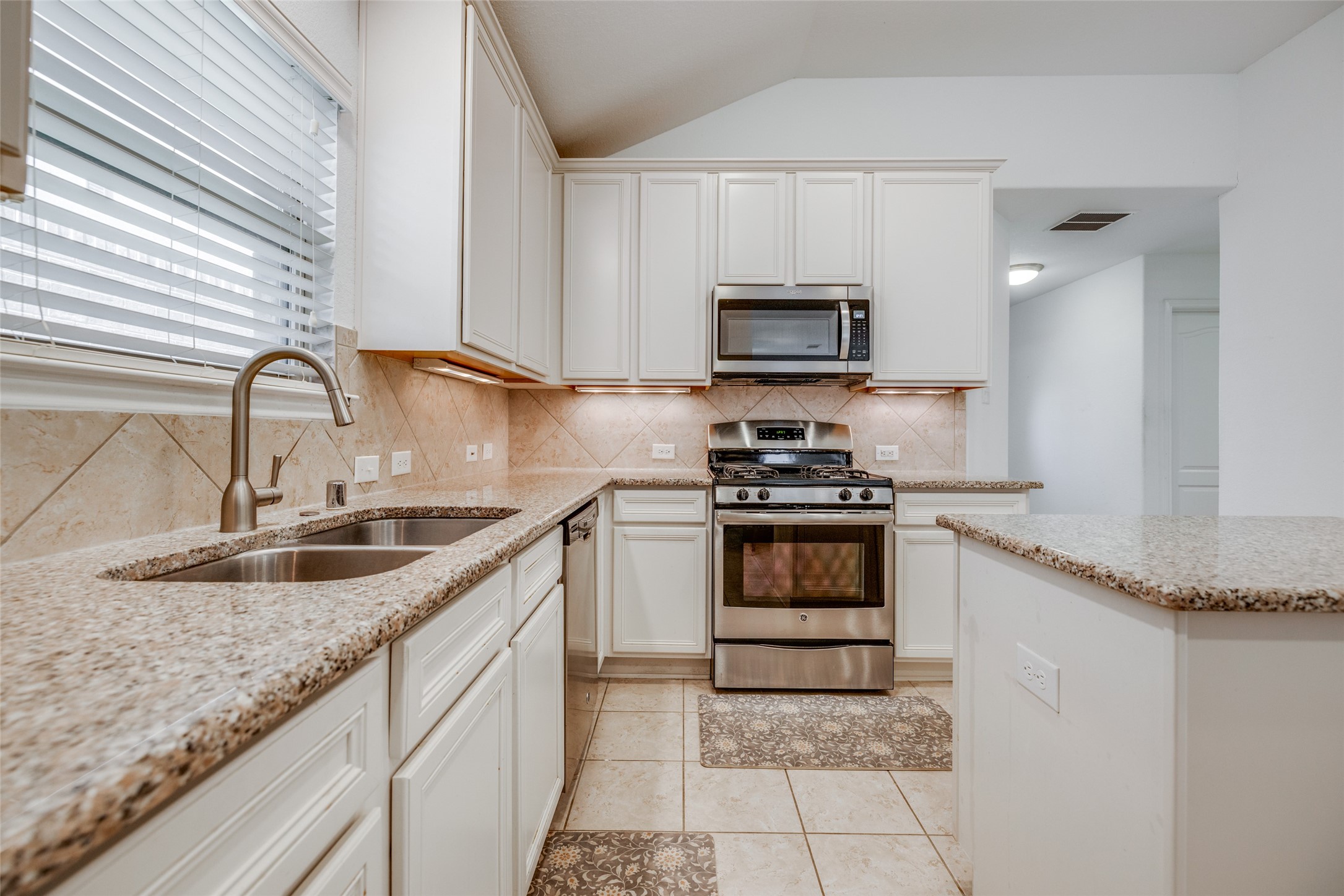 7123 Panther Ridge Drive Spring, TX 77389 - Photo 14 of 31 a kitchen with granite countertop a sink a stove top oven and cabinetry