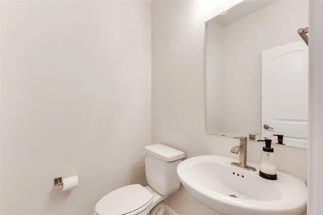 a bathroom with a sink a toilet and mirror