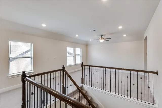 a view of a hallway with a ceiling fan
