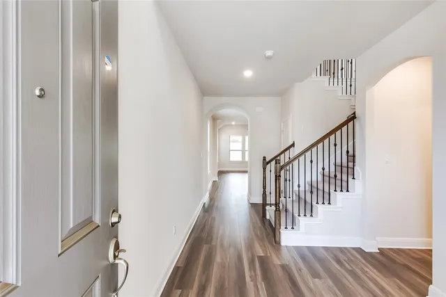 a view of a hallway with wooden floor and staircase