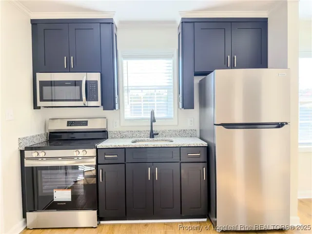 a kitchen with a stove a refrigerator and a microwave