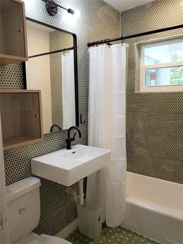 a bathroom with a sink toilet and shower