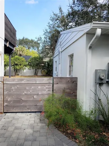 a view of backyard with wooden fence and a large tree