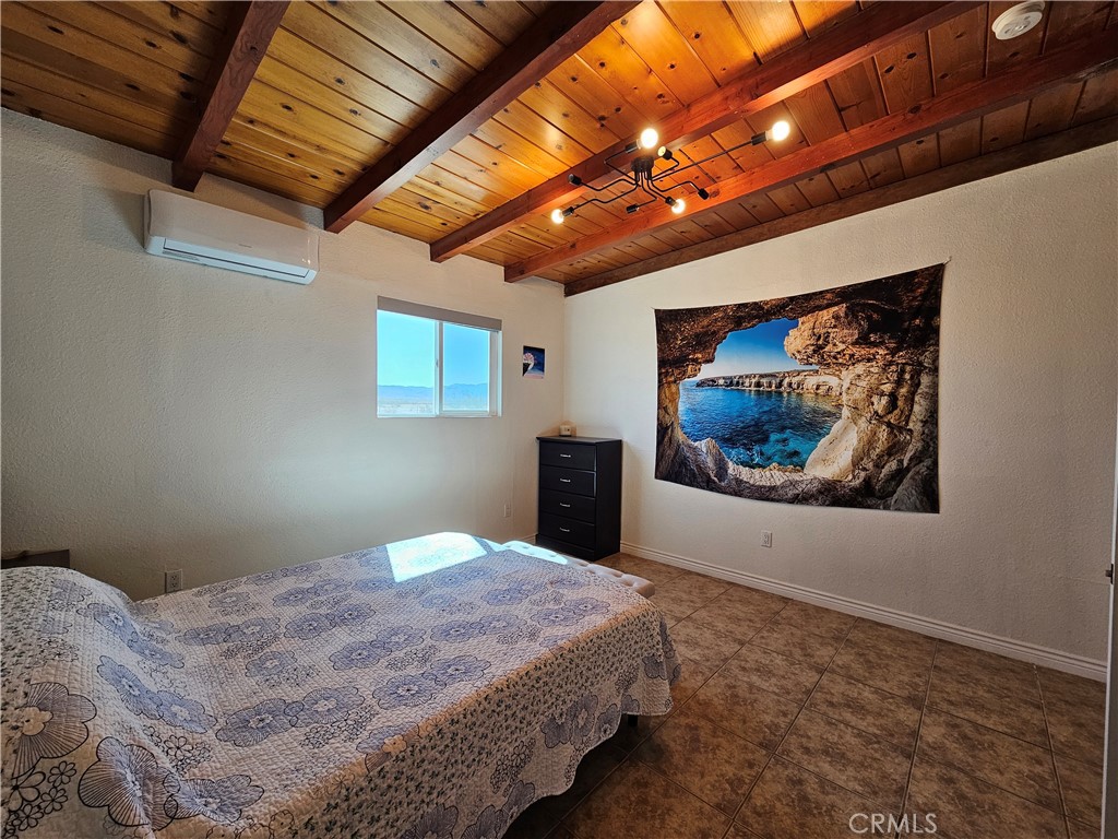 3939 Pinto Mountain Road Twentynine Palms, CA 92277 - Photo 15 of 47 a bedroom with a bed and a painting on the wall