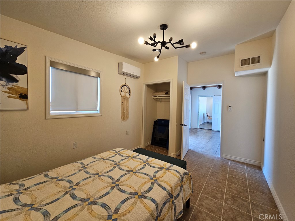 3939 Pinto Mountain Road Twentynine Palms, CA 92277 - Photo 5 of 47 a bedroom with a bed and a chandelier