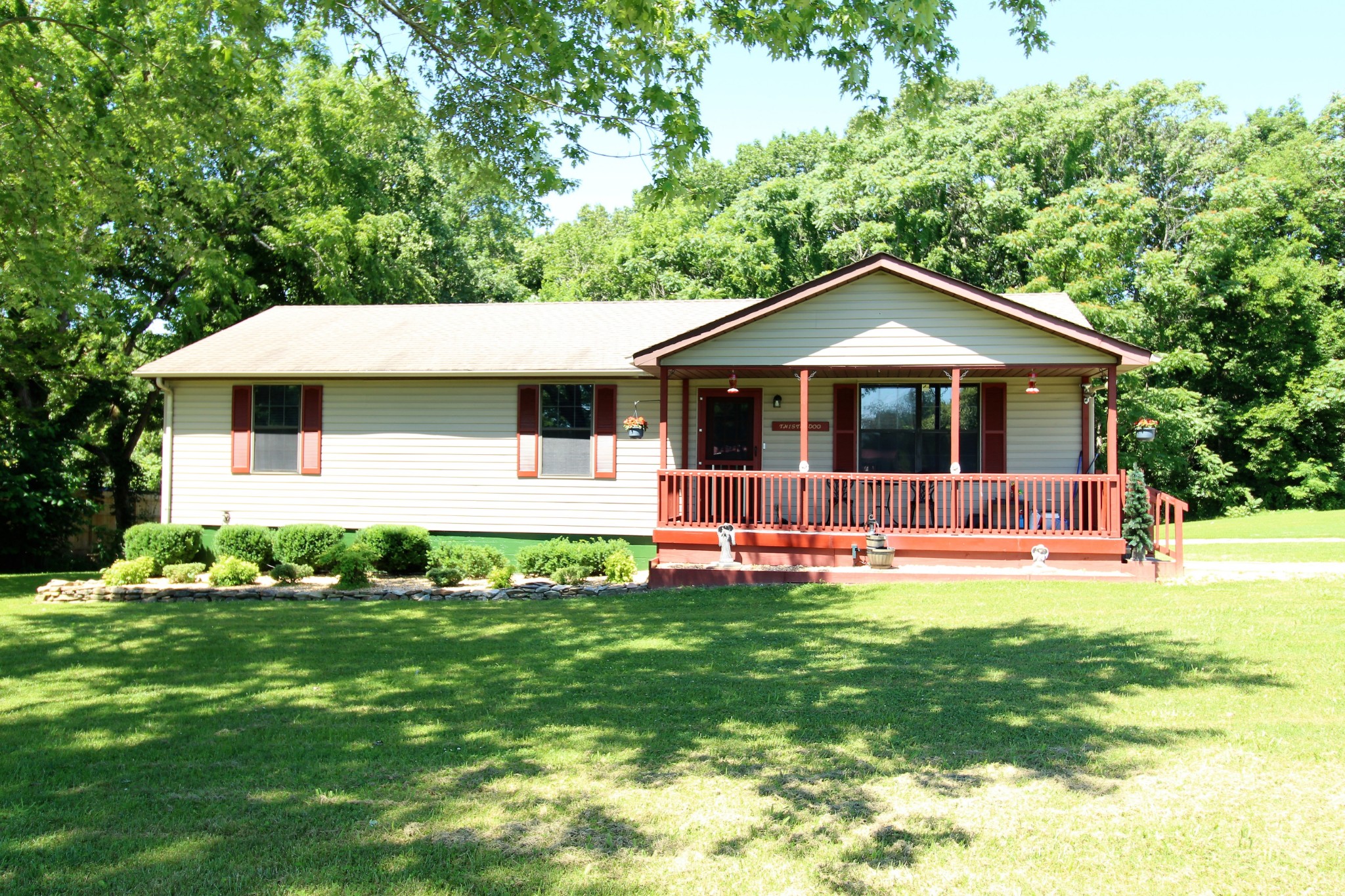 a front view of a house with a yard porch and green space
