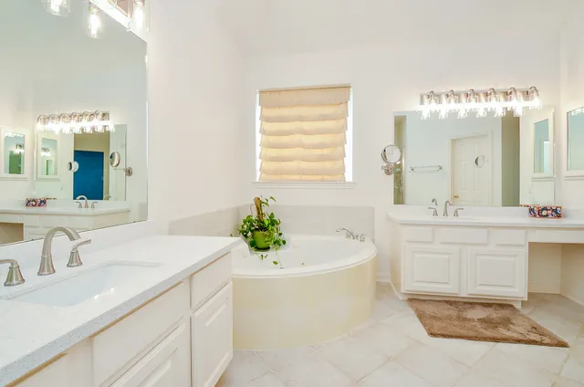 a bathroom with a sink a bathtub a mirror and vanity