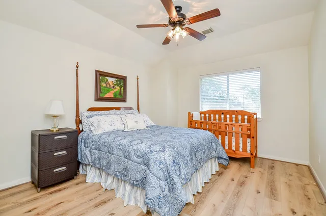 a bedroom with a bed and wooden floor