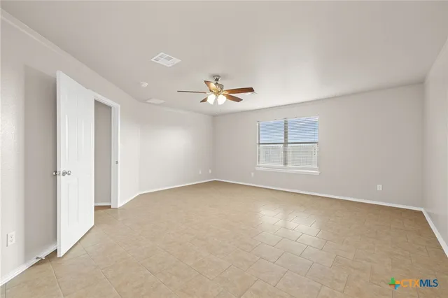 an empty room with windows and ceiling fan view