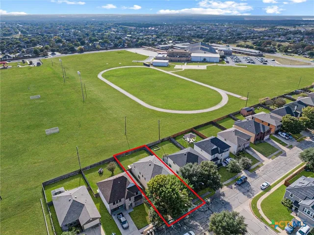 an aerial view of a residential houses with outdoor space and a swimming pool