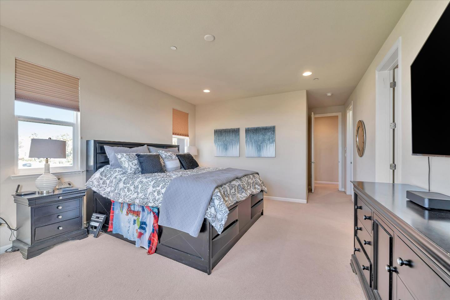 3001 Ruby Avenue San Jose, CA 95135 - Photo 31 of 58 a spacious bedroom with a bed a couch and a flat tv screen on a dresser