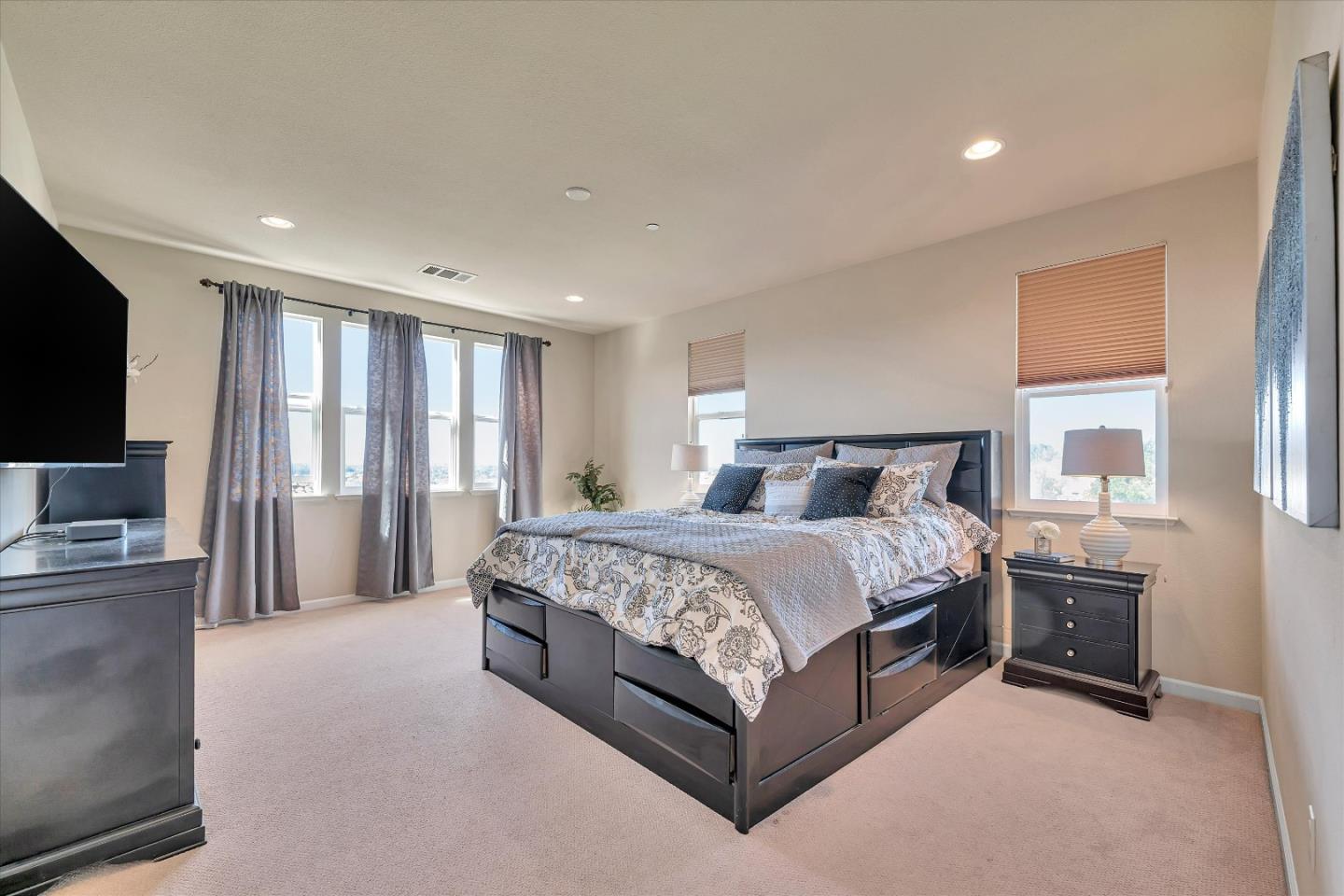 3001 Ruby Avenue San Jose, CA 95135 - Photo 32 of 58 a spacious bedroom with a bed and a flat screen television