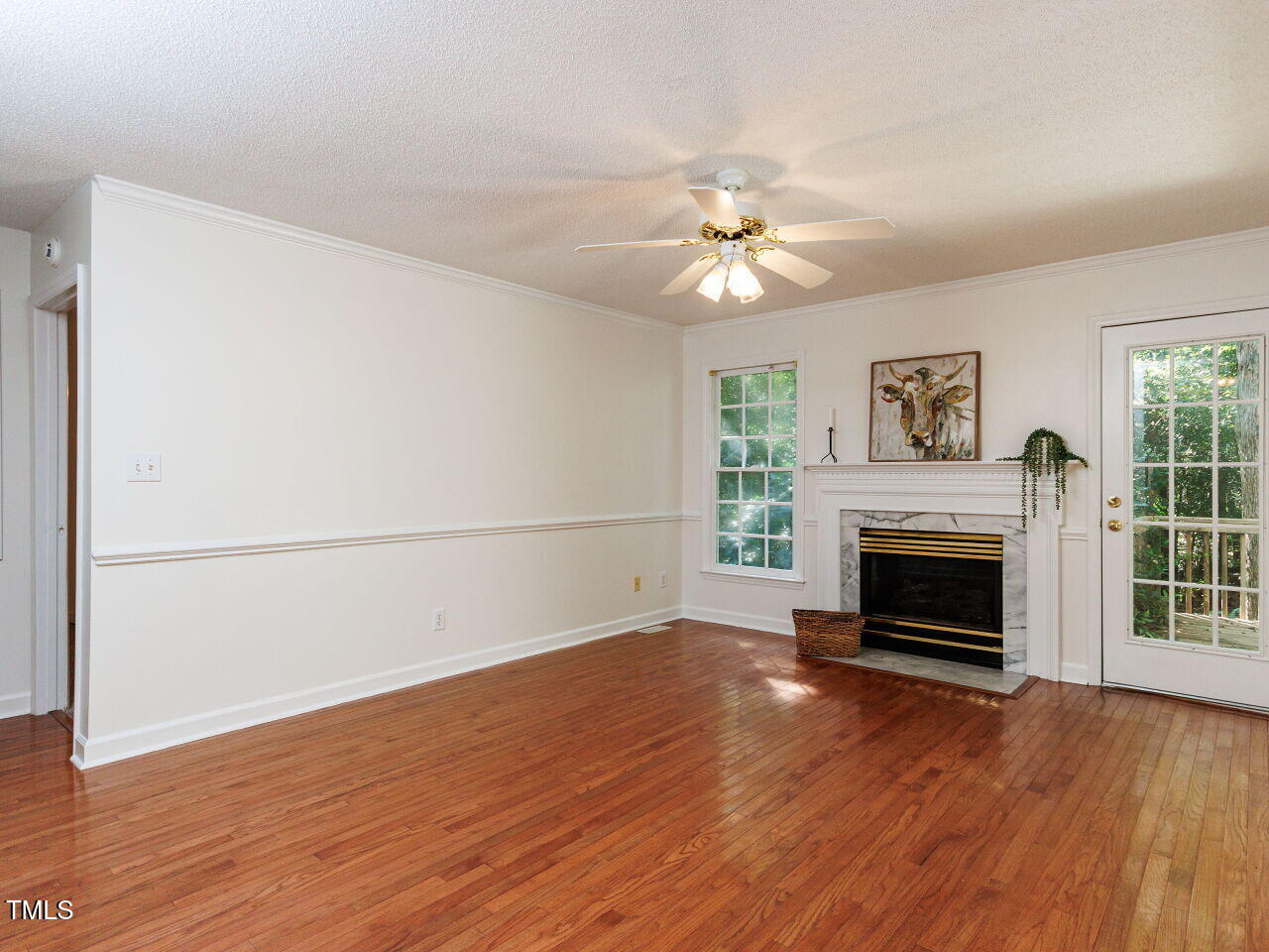 216 Deep Pool Court Benson, NC 27504 - Photo 5 of 37 an empty room with wooden floor fireplace cabinet and windows