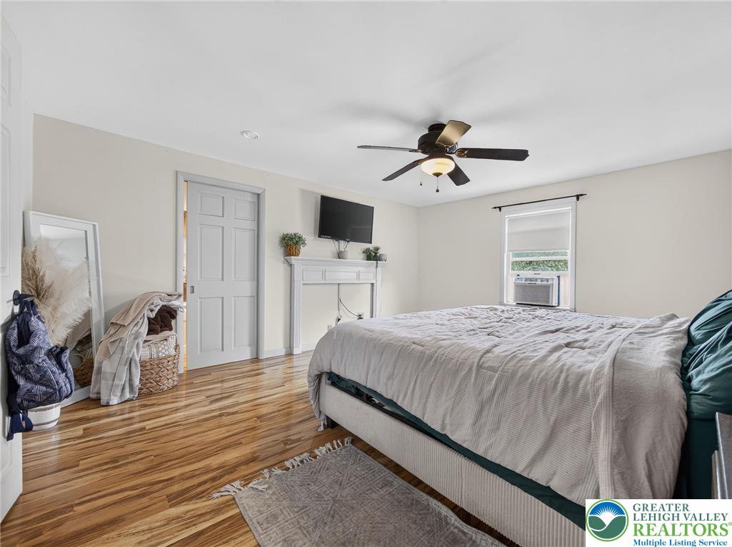 2628 Levans Road Coplay, PA 18037 - Photo 44 of 54 Wood flooring and a classic white fireplace mantel distinguish this comfortable bedroom.