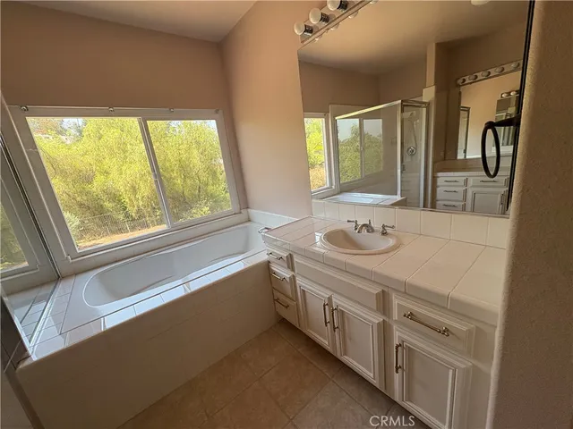 a bathroom with a granite countertop sink and a large mirror