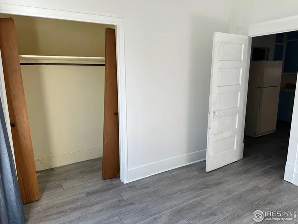an empty room with wooden floor and entrance
