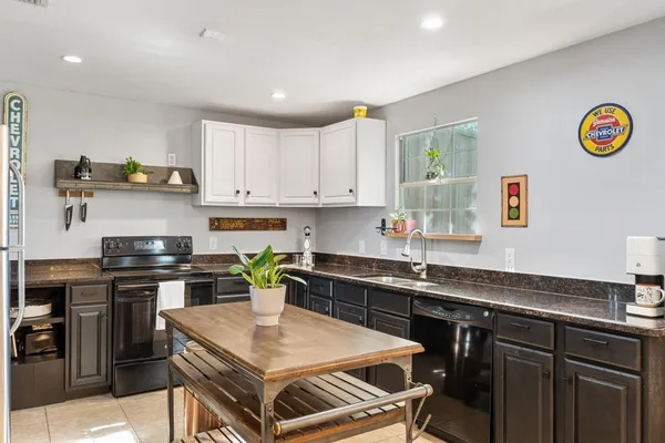 a kitchen with a stove a sink a dining table and chairs