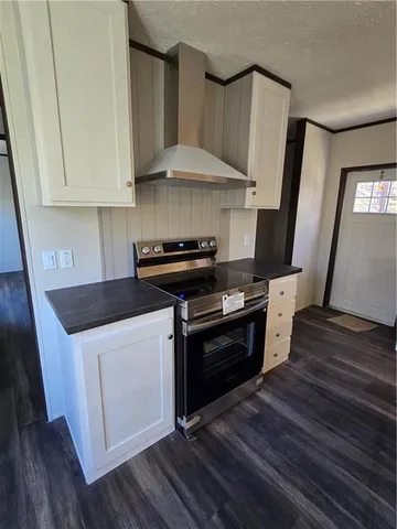 a kitchen with granite countertop a stove and a wooden floor