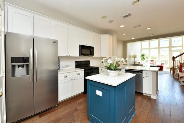 a kitchen with a refrigerator a sink dishwasher with a dining table and chairs