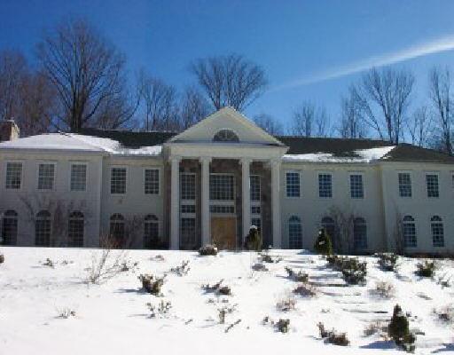 a view of a house with snow on the side of the road